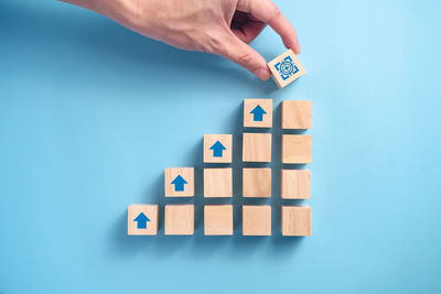 High angle view of hand playing with toy against blue background