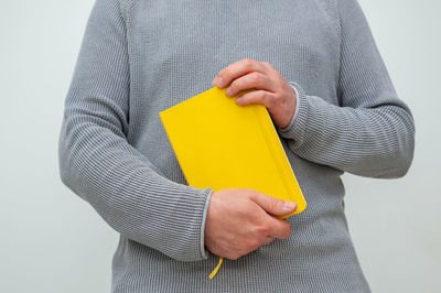 Close-up of man holding hands against white background