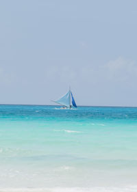 Sailboat in sea against sky