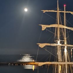 Sailboats in sea against sky at night