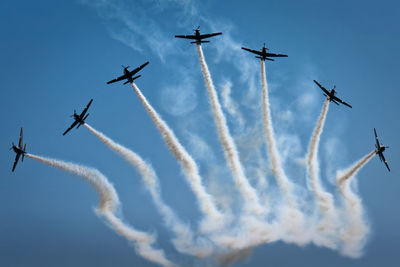 Low angle view of airshow against sky