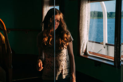 Woman standing in ferry by window