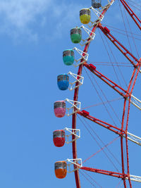 Low angle view of ferris wheel against blue sky