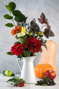 Elegant autumn bouquet with ripe apples and pumpkin on table. thanksgiving day