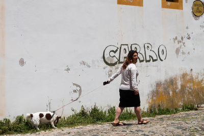 Full length of man standing against wall