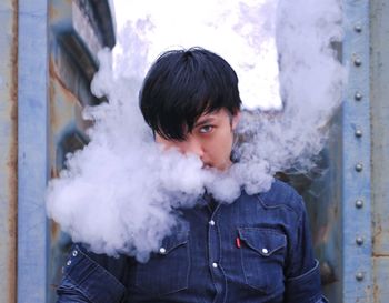 Portrait of young man smoking cigarette