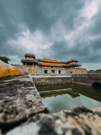 Bridge over river against cloudy sky