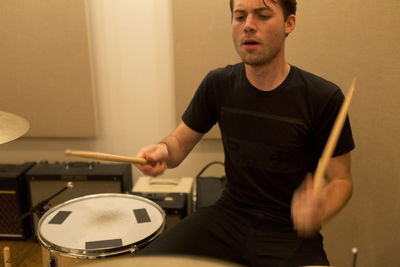 Young man drumming during a band rehearsal