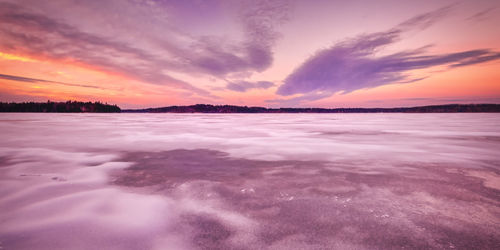 Scenic view of sea against dramatic sky during sunset