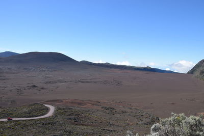 Scenic view of desert against clear blue sky