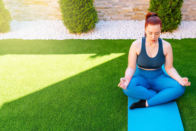 Young woman sitting on soccer field