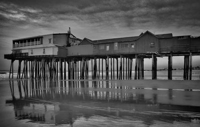 Pier over sea against cloudy sky