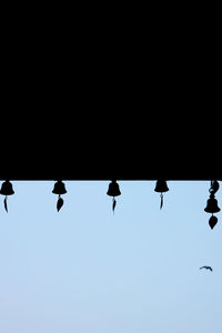 Low angle view of silhouette birds flying against clear sky