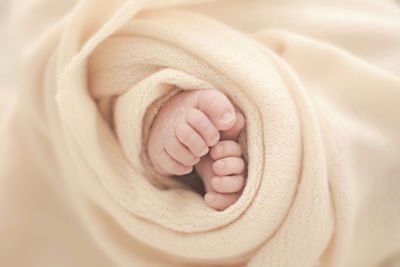 Low section of baby wrapped in blanket