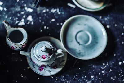 High angle view of kettle and plate on table