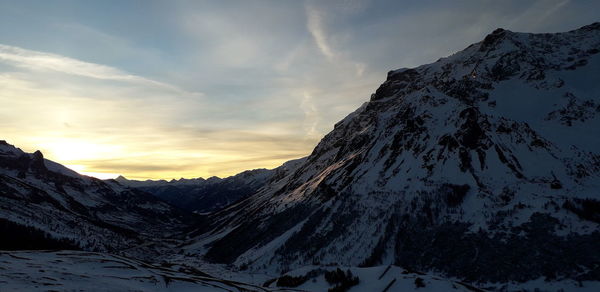 Scenic view of snowcapped mountains against sky during sunset