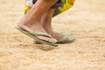 Low section of person walking on sand at beach