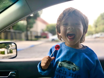 Smiling boy eating candy in car