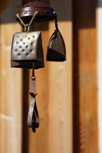 Close-up of antique decoration hanging against wooden wall