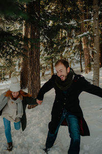 Full length of couple walking on snow covered landscape