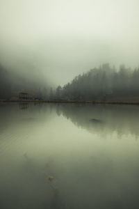 Scenic view of lake against sky during foggy weather