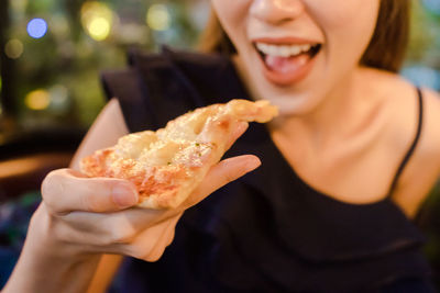 Close-up of woman eating pizza
