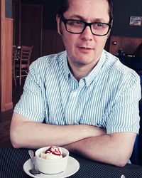 Man with ice cream on table at restaurant