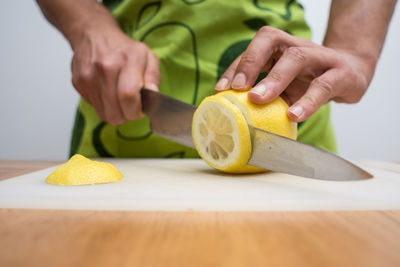 Midsection of man cutting lime on table