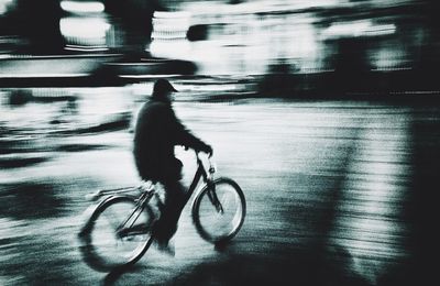 Side view of man riding bicycle on street