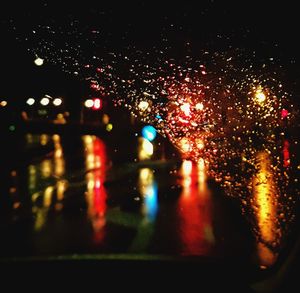 Defocused image of car on illuminated road at night