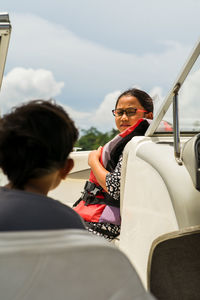 Side view of girl talking to brother in boat