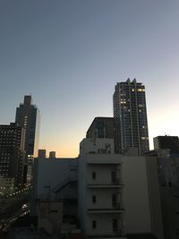 Modern buildings against sky during sunset