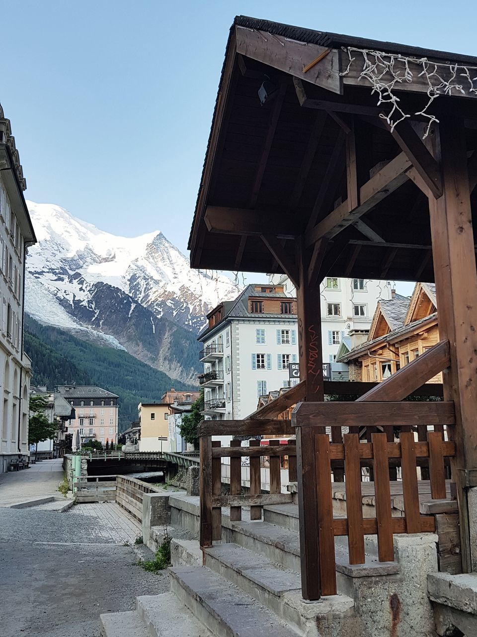 HOUSES BY SNOWCAPPED MOUNTAINS AGAINST SKY