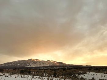 Scenic view of snowcapped mountains against sky during sunset