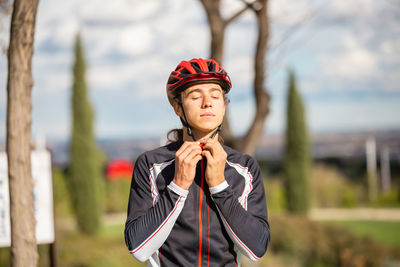 Portrait of young woman standing against blurred background