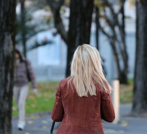 Rear view of woman standing against tree