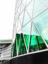 Low angle view of modern glass building against sky