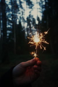 Close-up of hand holding sparkler at night