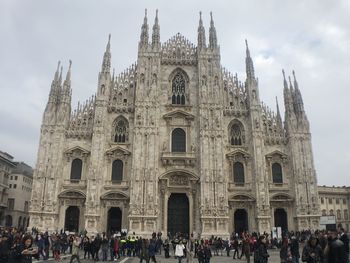 Group of people outside cathedral against sky