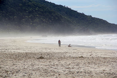 People on beach against sky