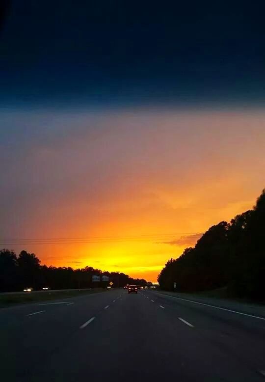 road, transportation, sunset, the way forward, sky, road marking, car, silhouette, street, diminishing perspective, country road, land vehicle, cloud - sky, tranquility, scenics, tranquil scene, vanishing point, orange color, beauty in nature, nature