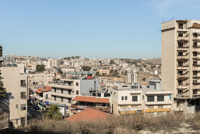 Buildings in city against clear blue sky