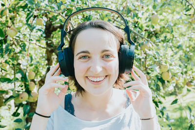 Portrait of young woman standing against plants