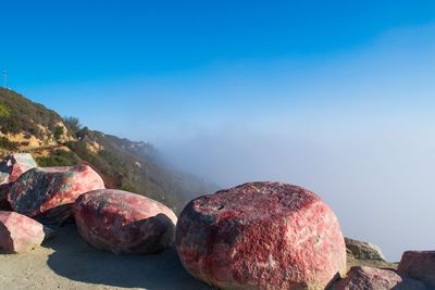 High angle view of rocks at the edge of road against sky during foggy weather