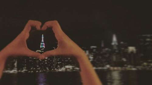 Close-up of hand holding camera at night