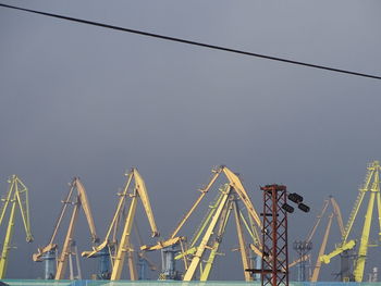 Low angle view of cranes against sky