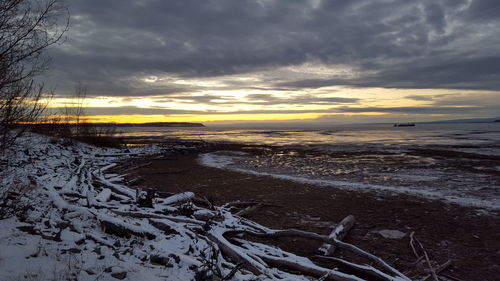 Scenic view of sea against cloudy sky during winter