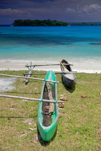 Green canoe on the beach