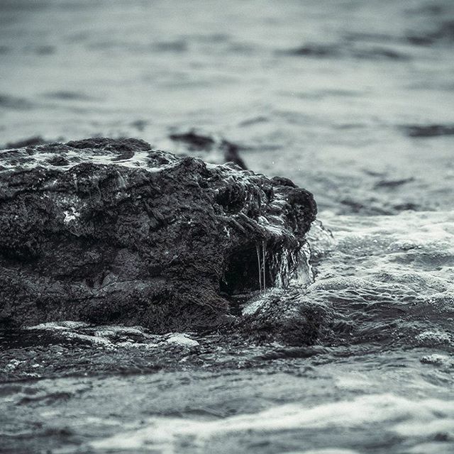 water, sea, rock - object, selective focus, nature, rock, focus on foreground, rock formation, close-up, beauty in nature, tranquility, rough, day, waterfront, beach, outdoors, motion, wave, shore, surface level