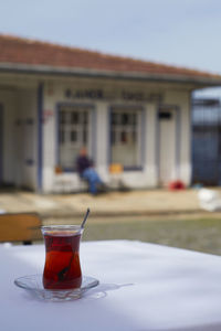 Close-up of tea in glass on table against building